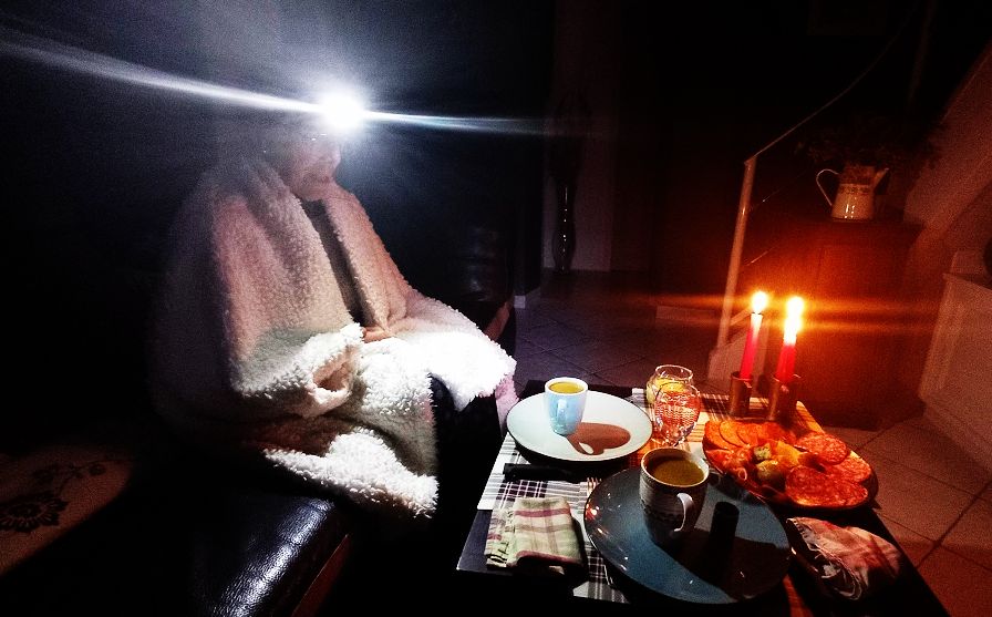 dame qui prend son repas en s'éclairant à la bougie