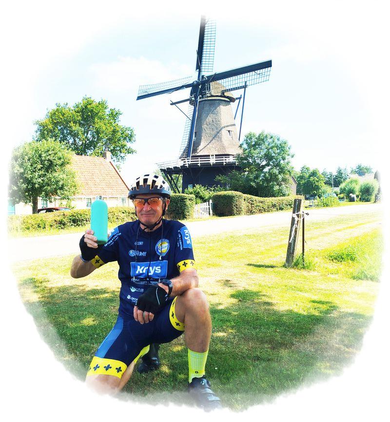 cycliste posant devant un moulin...